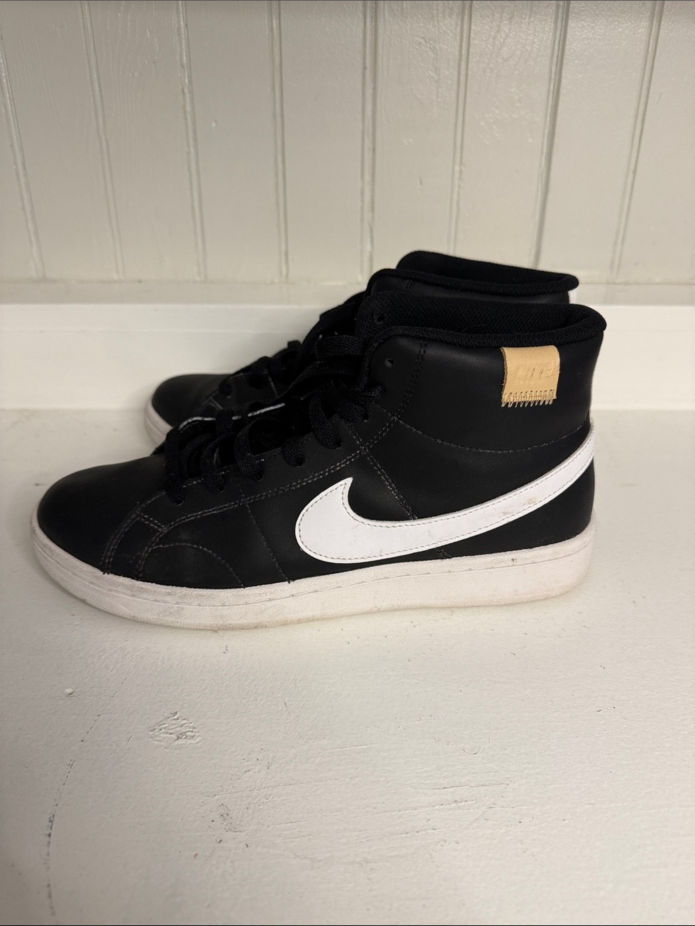 Nike women’s Black High-Top Sneakers with White Swoosh